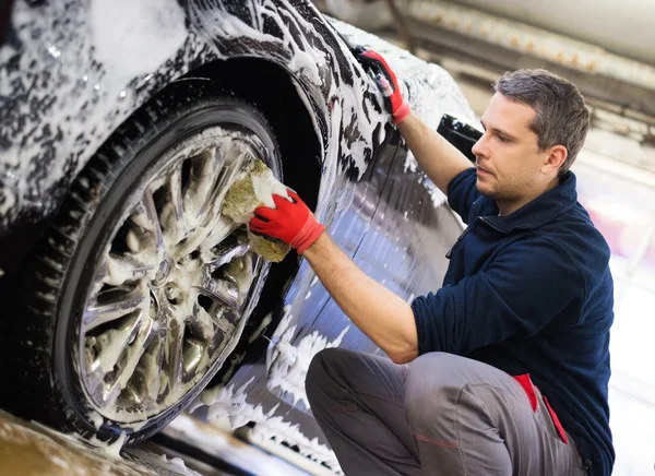 Homme travailleur laver les roues en alliage de voiture — Photo