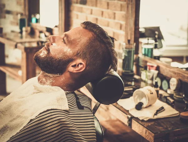 Opdrachtgever tijdens baard scheren in kapperszaak — Stockfoto