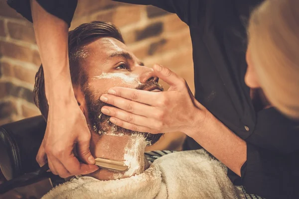 Клієнт під час гоління бородою в перукарні — стокове фото