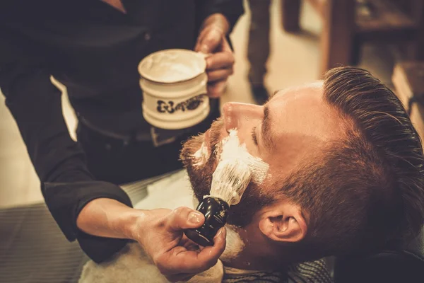 Client during beard shaving in barber shop — Stock Photo, Image