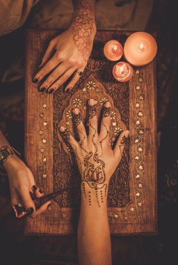 Drawing process of henna mehndi ornament on woman's hand clipart