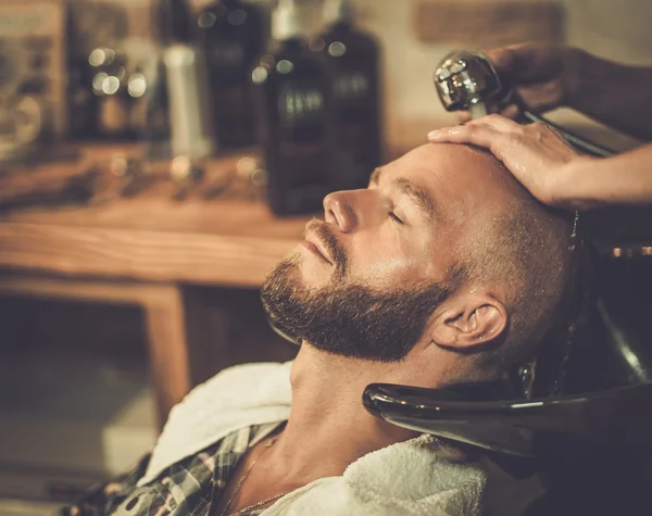 Cabeleireiro lavar o cabelo do cliente na barbearia — Fotografia de Stock