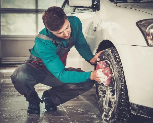 Man arbetstagaren tvätta bilens legering fälgar — Stockfoto