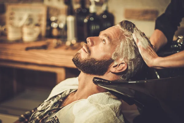 Peluquero lavando el cabello del cliente en la peluquería — Foto de Stock