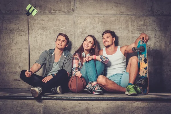 Amigos alegres con con el monopatín tomando selfie — Foto de Stock