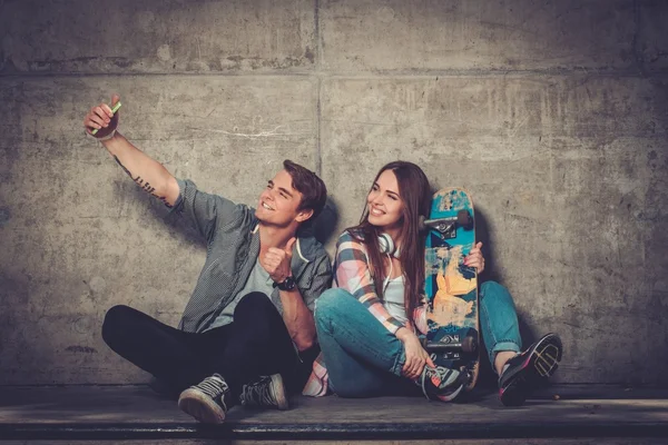Pareja joven con monopatín tomando selfie —  Fotos de Stock