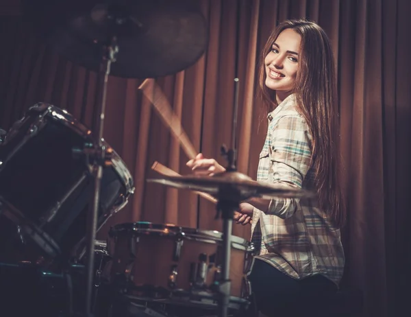 Vrolijk meisje achter drums op een repetitie — Stockfoto