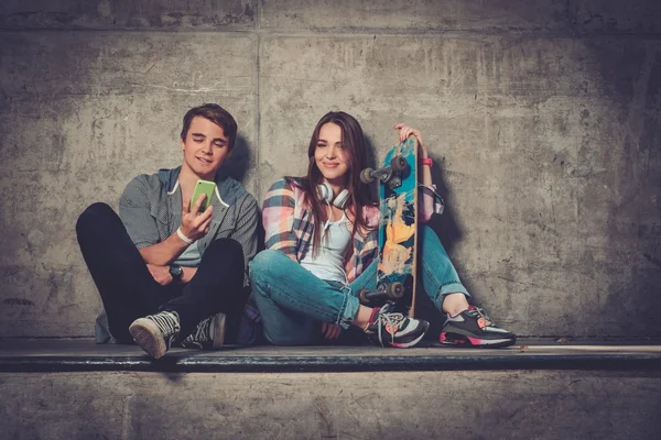 Jeune couple avec skateboard — Photo