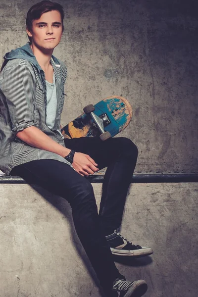 Schöner junger Mann mit Skateboard — Stockfoto