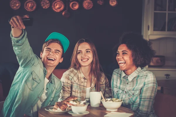 Multiraciale vrienden nemen selfie in een café — Stockfoto