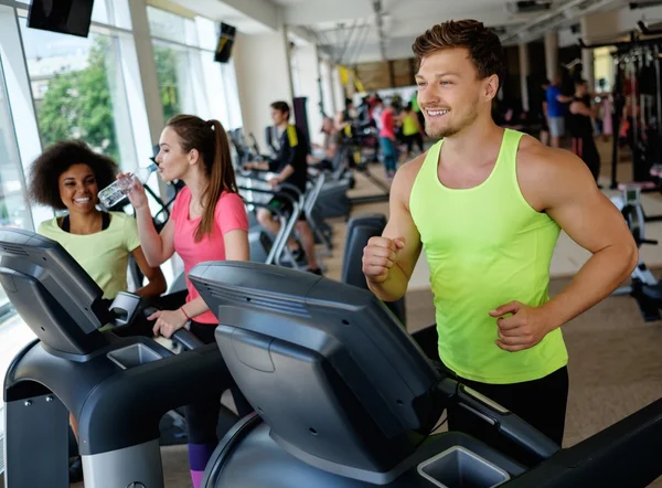 Hombre corriendo en una cinta de correr en un gimnasio — Foto de Stock