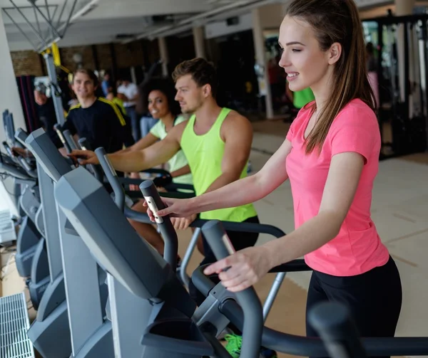 Personnes faisant de l'exercice sur une machine d'entraînement cardio — Photo