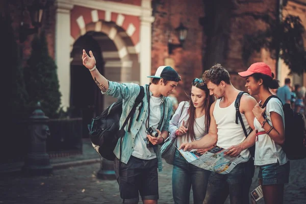 Amici multirazziali turisti con mappa in una città vecchia — Foto Stock