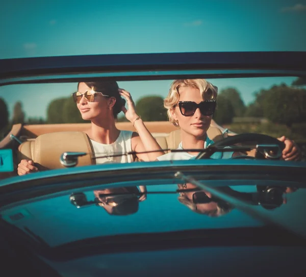 Две стильные дамы в классическом кабриолете — стоковое фото