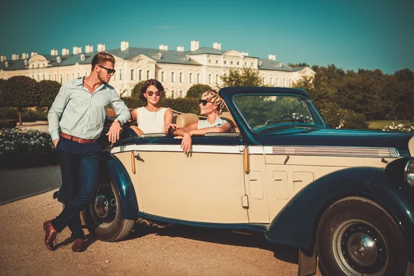 Vrienden in een klassieke cabriolet in de buurt van Koninklijk Paleis — Stockfoto