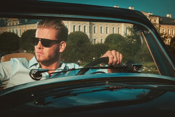 Man behind classic convertible steering wheel — Stock Photo, Image