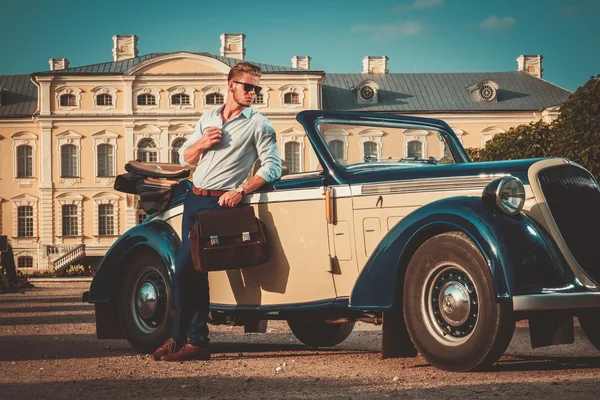 man with briefcase near classic convertible