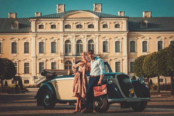 Пара рядом с классическим кабриолетом против королевского дворца — стоковое фото