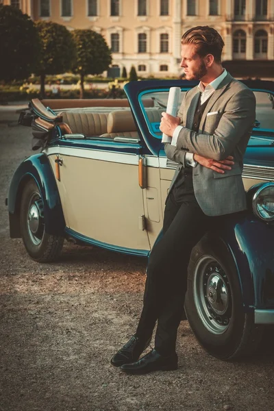 Man with newspaper near classic convertible — Stock Photo, Image