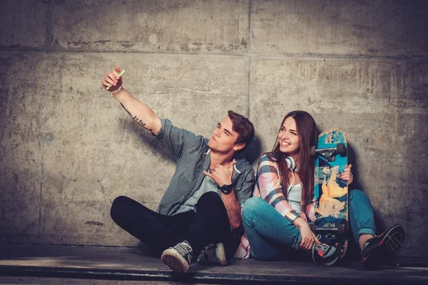 Młoda para z deskorolka biorąc pod selfie — Zdjęcie stockowe