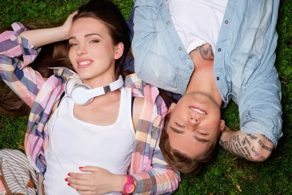 Couple lying on a grass in a park — Stock Photo, Image