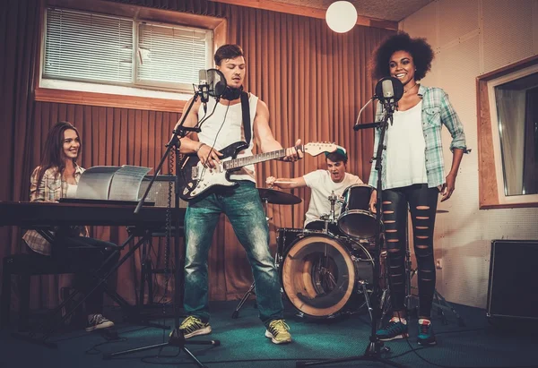 Banda de música multirracial se apresentando em estúdio — Fotografia de Stock