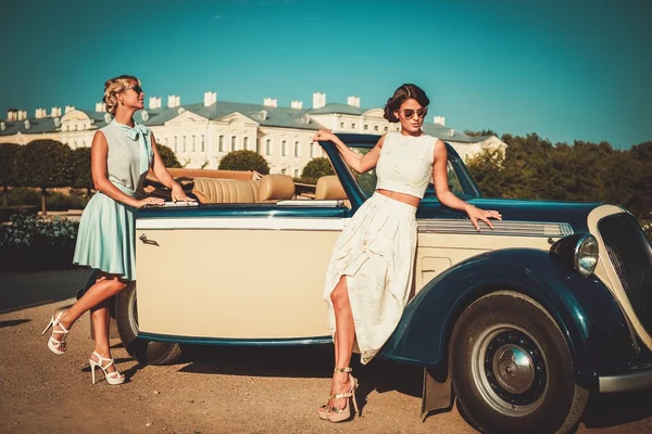 Två eleganta damer nära classic convertible — Stockfoto