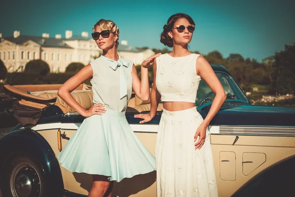 Due signore alla moda vicino alla cabriolet classica — Foto Stock