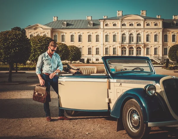 man with briefcase near classic convertible