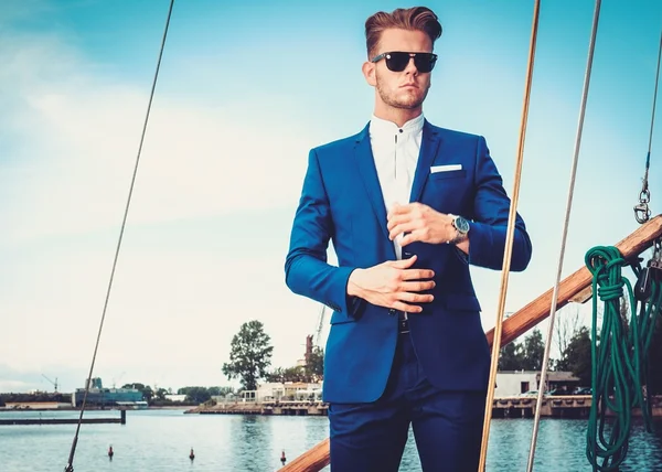 Stylish wealthy man on a luxury wooden regatta — Stock Photo, Image