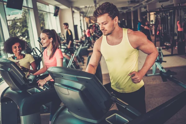 Bir spor salonunda bir koşu bandı üzerinde çalışan adam — Stok fotoğraf