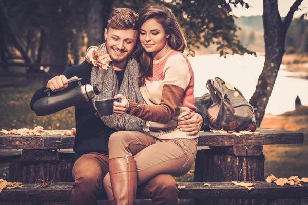 Vrolijke paar met warme dranken — Stockfoto