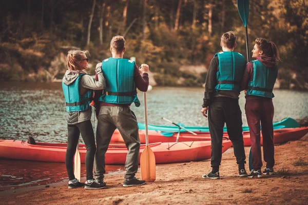 Grupa ludzi, Noszenie kamizelki w pobliżu kajaki na plaży — Zdjęcie stockowe