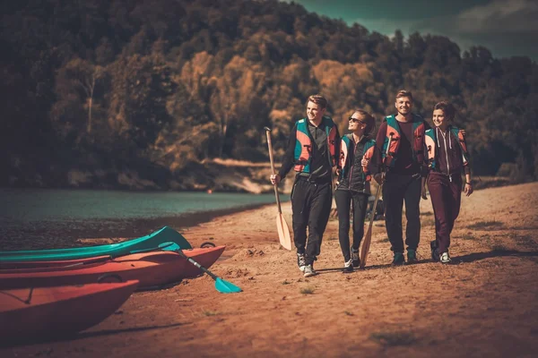 Gruppe von Menschen mit Schwimmwesten in der Nähe von Kajaks am Strand — Stockfoto