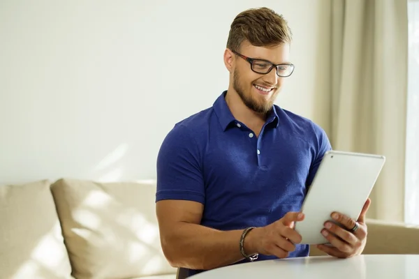 Przystojny mężczyzna w domu przy użyciu komputera typu tablet — Zdjęcie stockowe