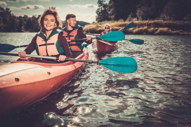Group of happy people on a kayaks clipart