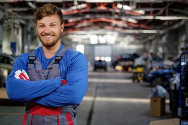 Cheerful serviceman in a car workshop clipart