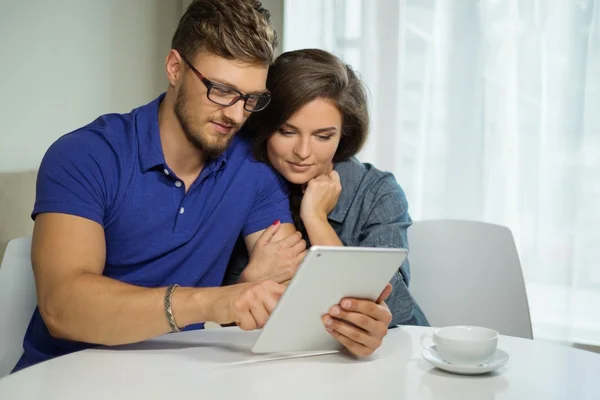 Pareja alegre con PC tableta en casa —  Fotos de Stock