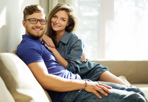 Cheerful couple on a sofa at home — Stock Photo, Image