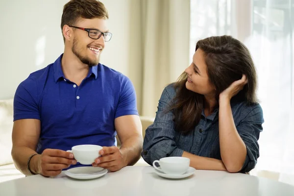 Cheerful couple behind table at home — Stock Photo, Image