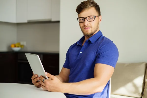 Kjekken mann som bruker tablett pc hjemme – stockfoto