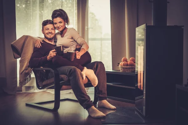 Young couple near fireplace at home — Stock Photo, Image