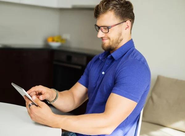 英俊的男人，在家里使用 tablet pc — 图库照片