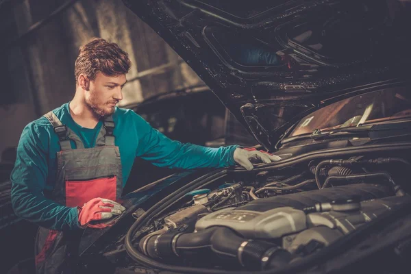 Mechaniker checkt unter Motorhaube in Werkstatt — Stockfoto