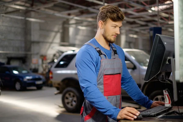 Specialista vicino al pc diagnostico dell'automobile in un'officina — Foto Stock