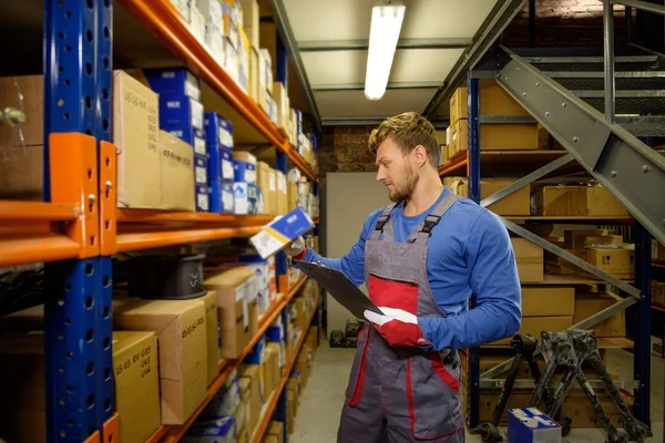 Werknemer op een magazijn voor auto-onderdelen — Stockfoto