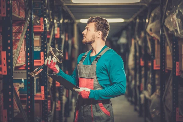 Werknemer op een magazijn voor auto-onderdelen — Stockfoto