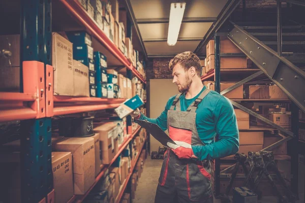 Werknemer op een magazijn voor auto-onderdelen — Stockfoto