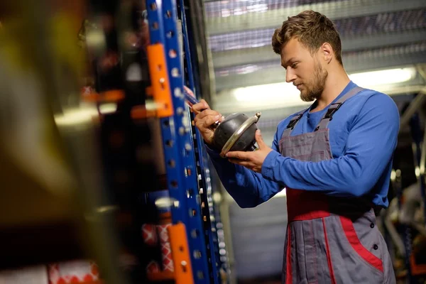 Werknemer op een magazijn voor auto-onderdelen — Stockfoto