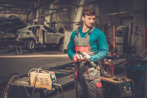 Mechanic with welding machine in a workshop — Stock Photo, Image